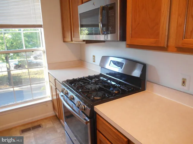 a kitchen with a sink a microwave a refrigerator and cabinets