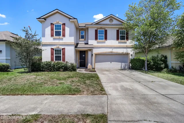 a front view of a house with a yard and garage