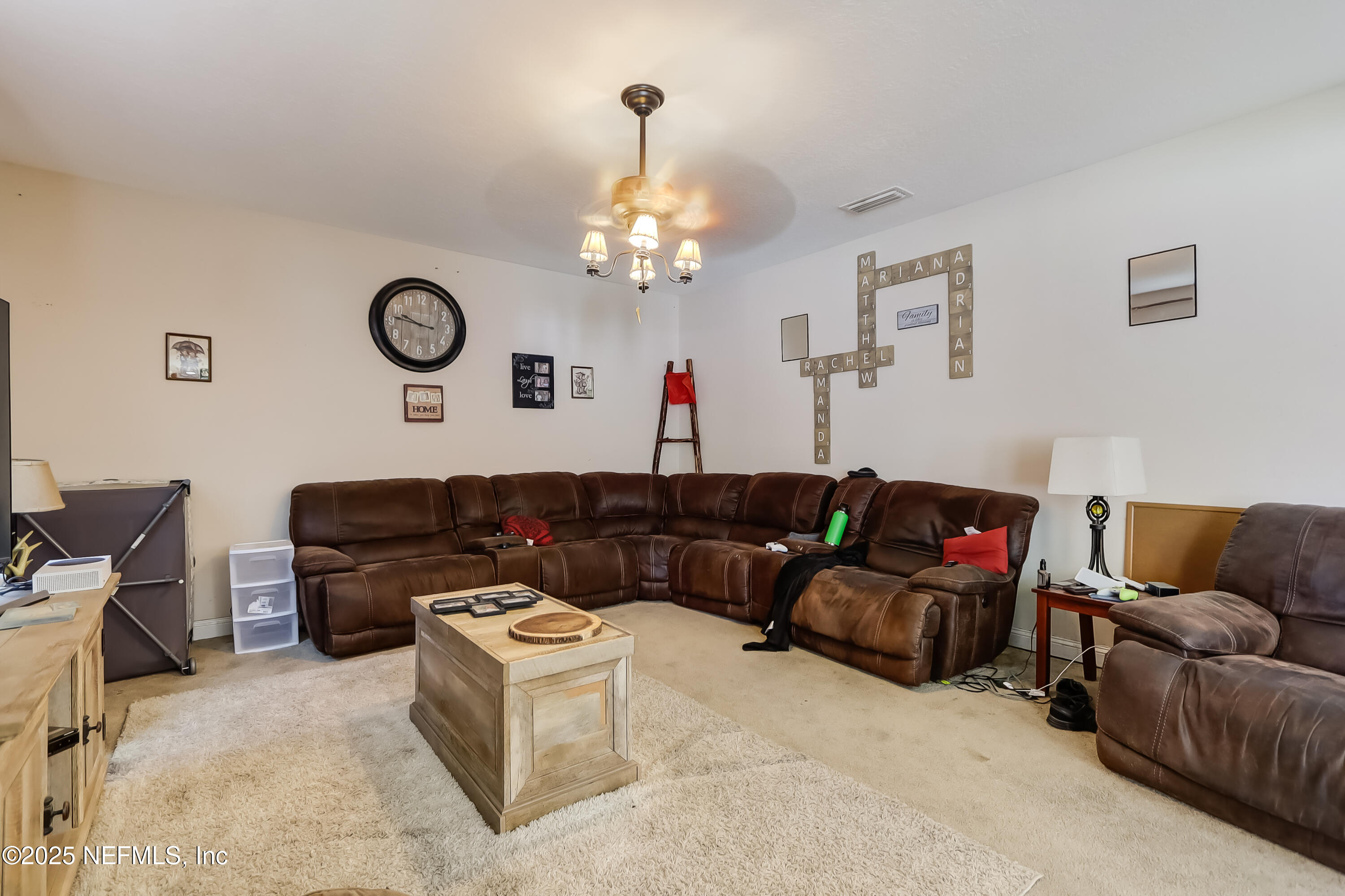 1071 Wetland Ridge Circle Middleburg, FL 32068 - Photo 11 of 41 a living room with furniture a couch and a chandelier