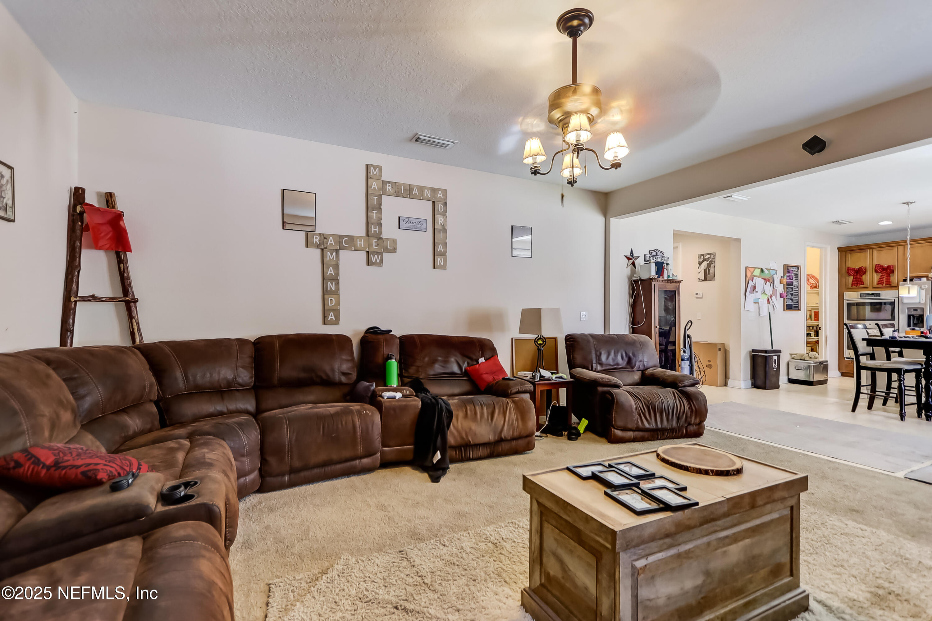 1071 Wetland Ridge Circle Middleburg, FL 32068 - Photo 12 of 41 a living room with furniture a rug and a chandelier