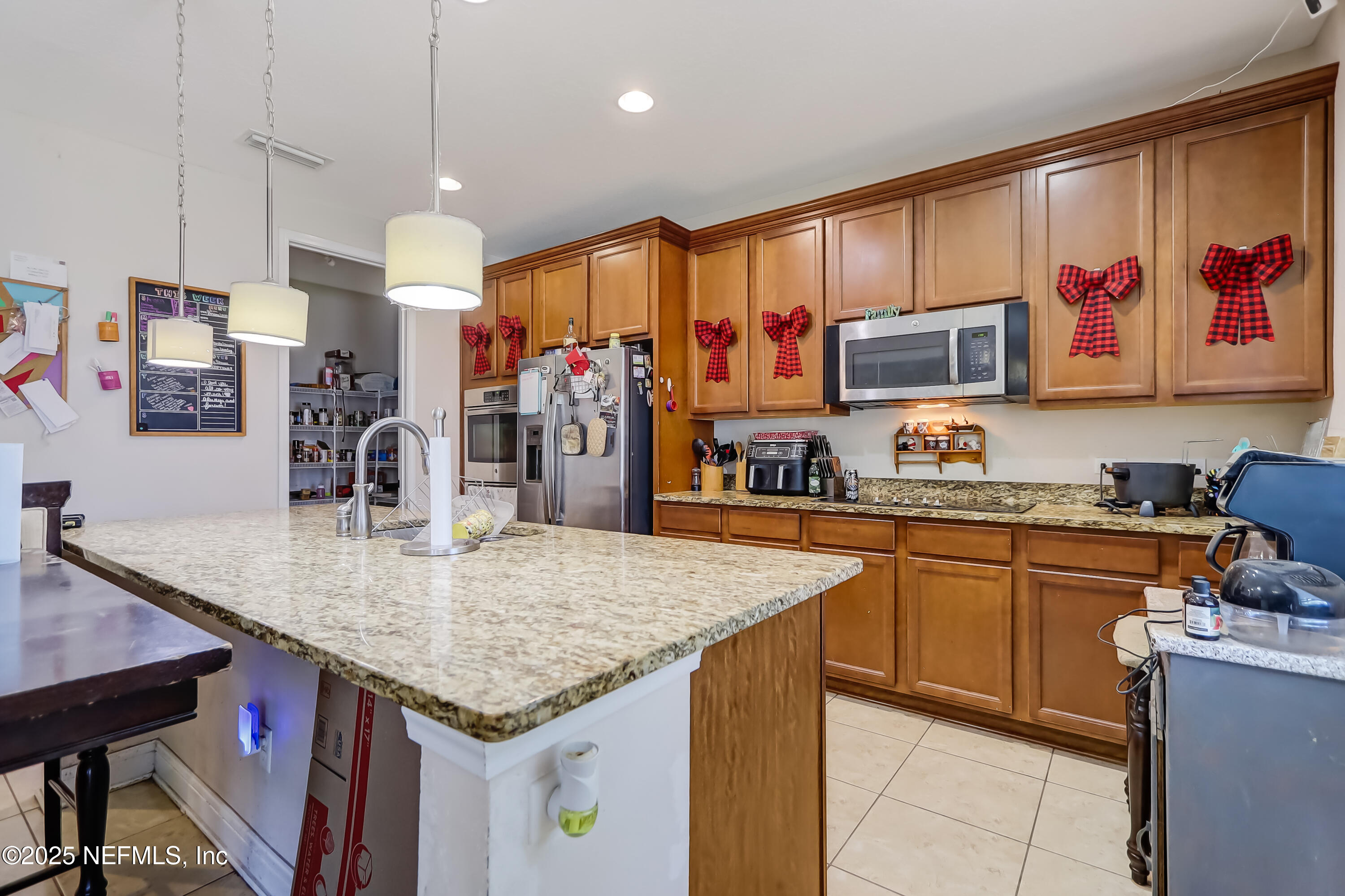 1071 Wetland Ridge Circle Middleburg, FL 32068 - Photo 15 of 41 a kitchen with stainless steel appliances granite countertop a sink dishwasher and refrigerator with wooden cabinets
