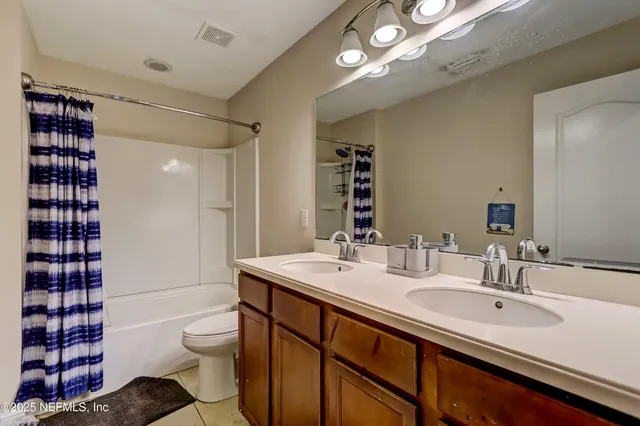 a bathroom with a sink toilet double vanity and shower