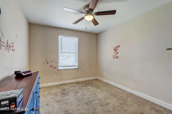 an empty room with a window and a ceiling fan