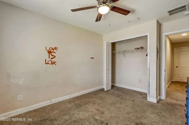 a view of a workspace with furniture and a ceiling fan
