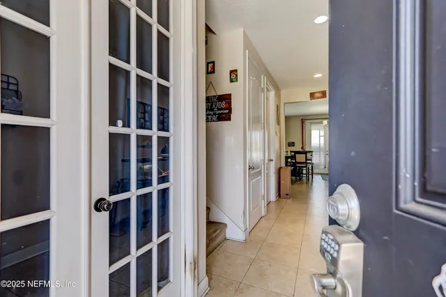 a hallway with closet and a large window