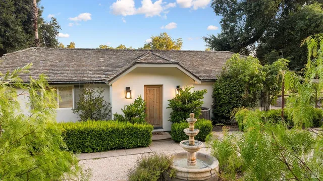 a view of a house with a yard and potted plants
