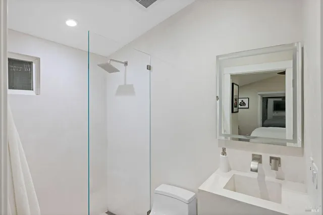 a bathroom with a sink a toilet and mirror