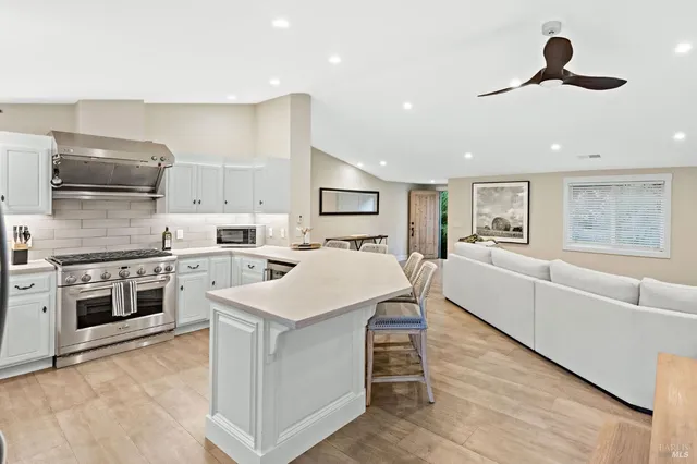 a large white kitchen with stainless steel appliances