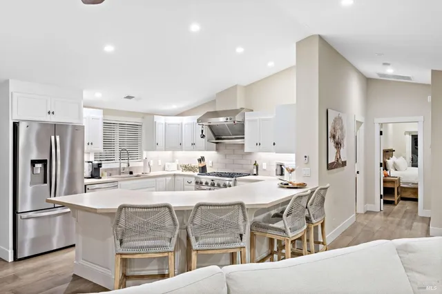 a kitchen with stainless steel appliances kitchen island granite countertop a refrigerator and a stove top oven