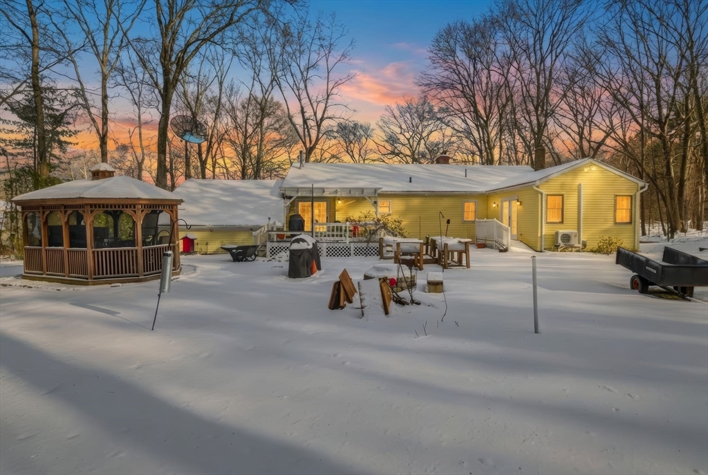 9 East Hill Road Monson, MA 01057 - Photo 39 of 41 a view of a patio with table and chairs under an umbrella with large trees