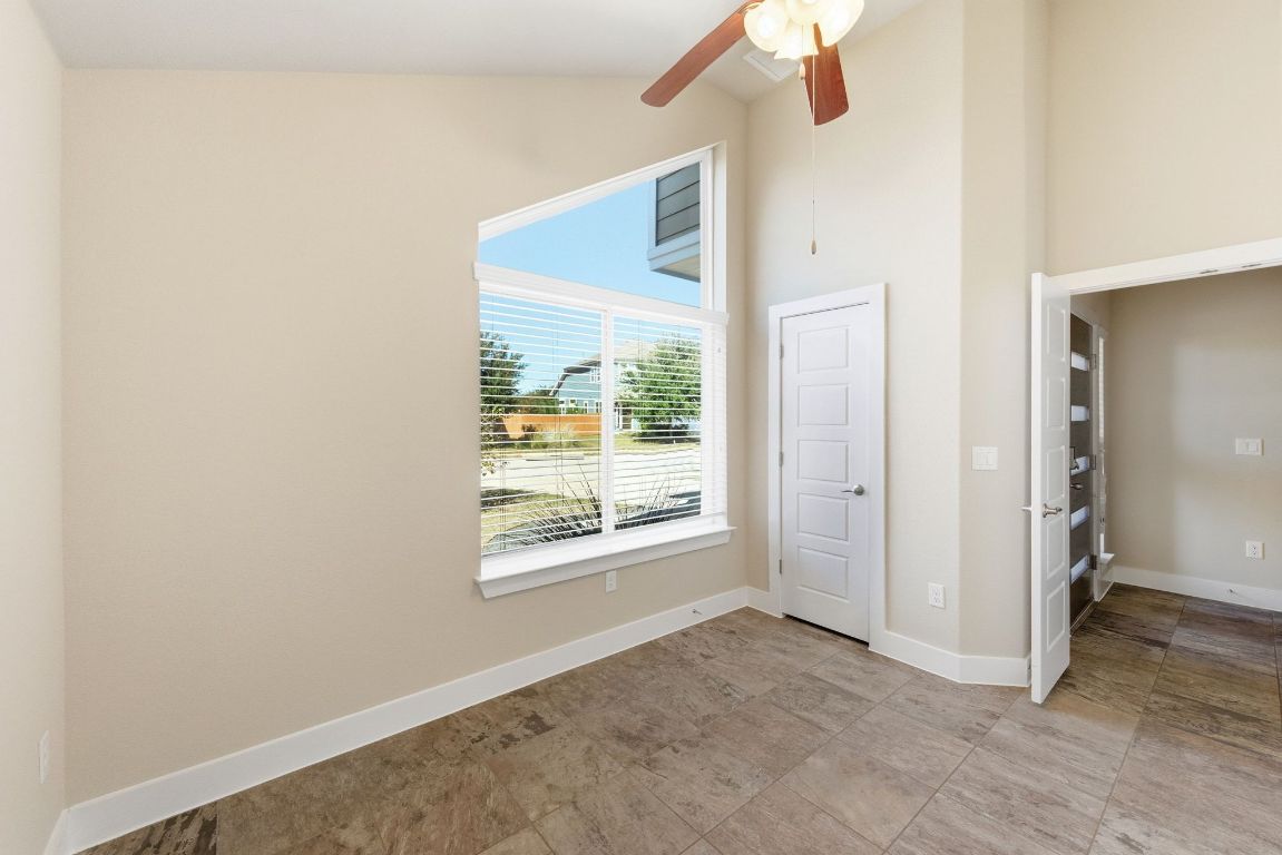 7013 Brick Slope Path Austin, TX 78744 - Photo 22 of 28 Empty room featuring ceiling fan and high vaulted ceiling