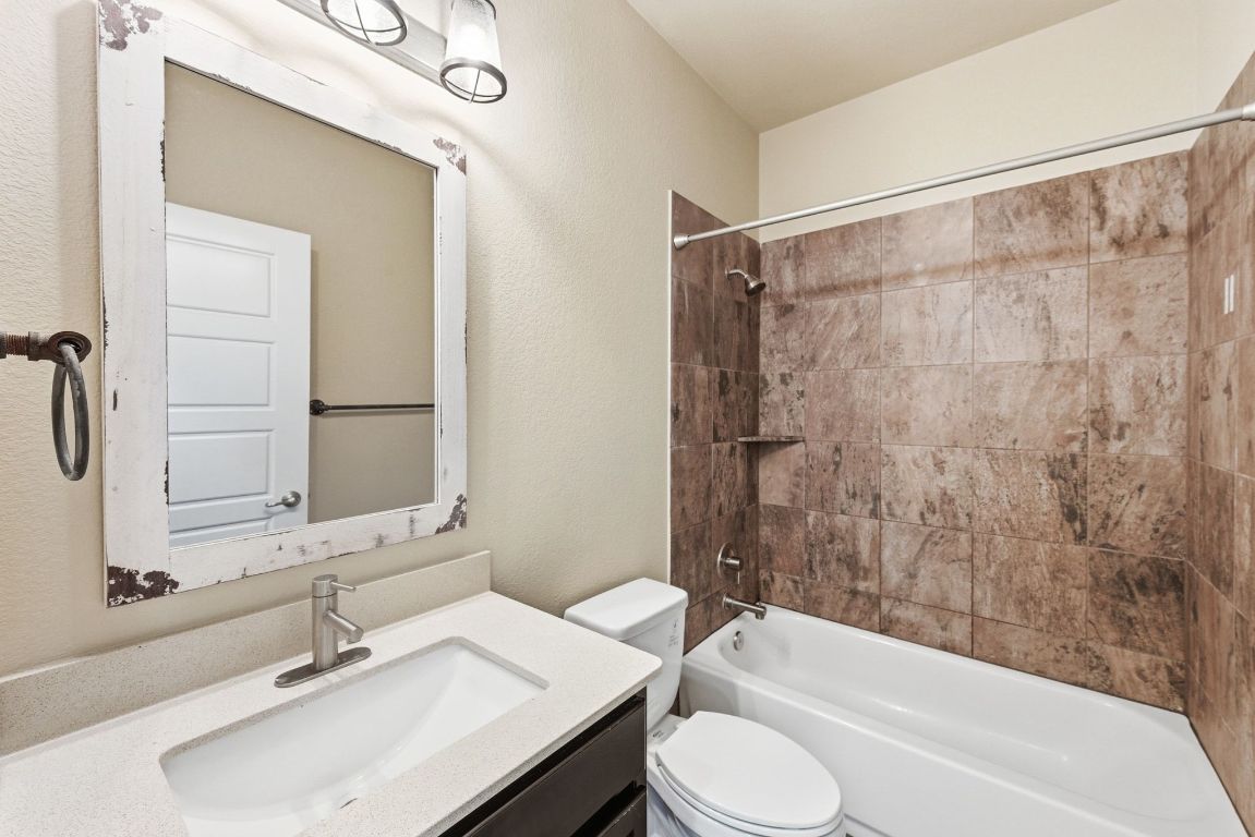 7013 Brick Slope Path Austin, TX 78744 - Photo 23 of 28 Full bath with vanity, shower / tub combination, and a textured wall