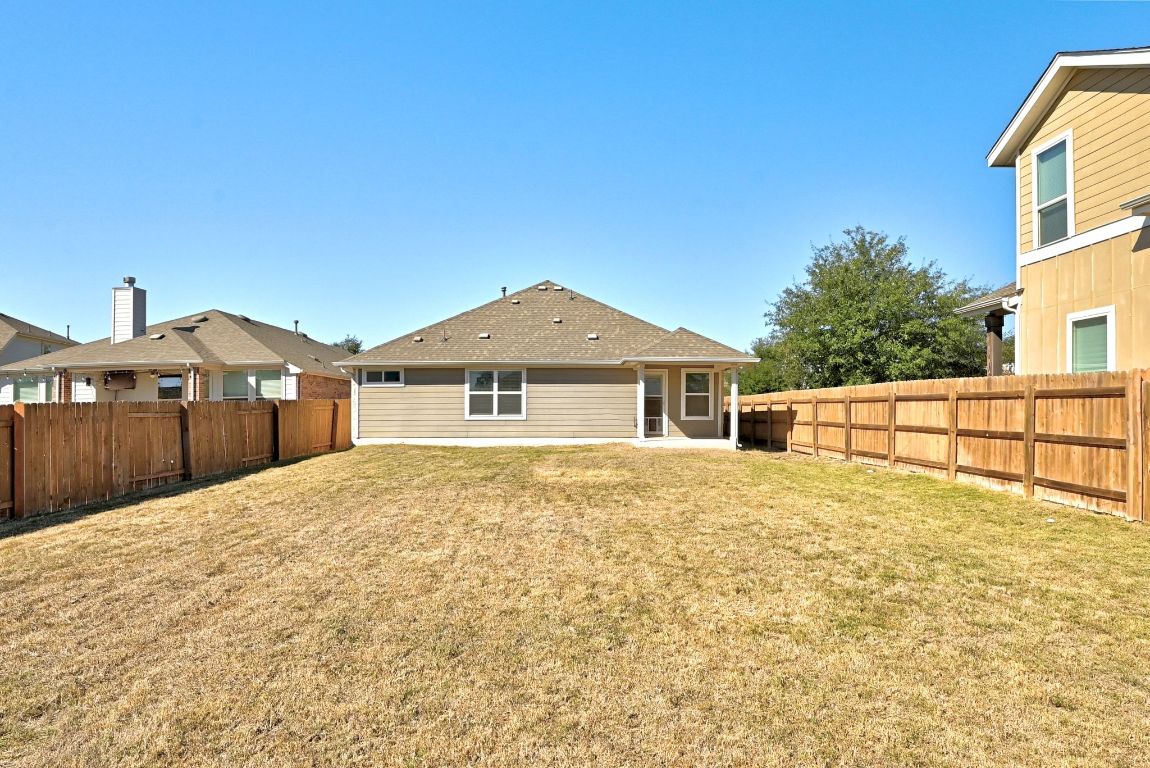 7013 Brick Slope Path Austin, TX 78744 - Photo 25 of 28 Back of house with a patio and a fenced backyard