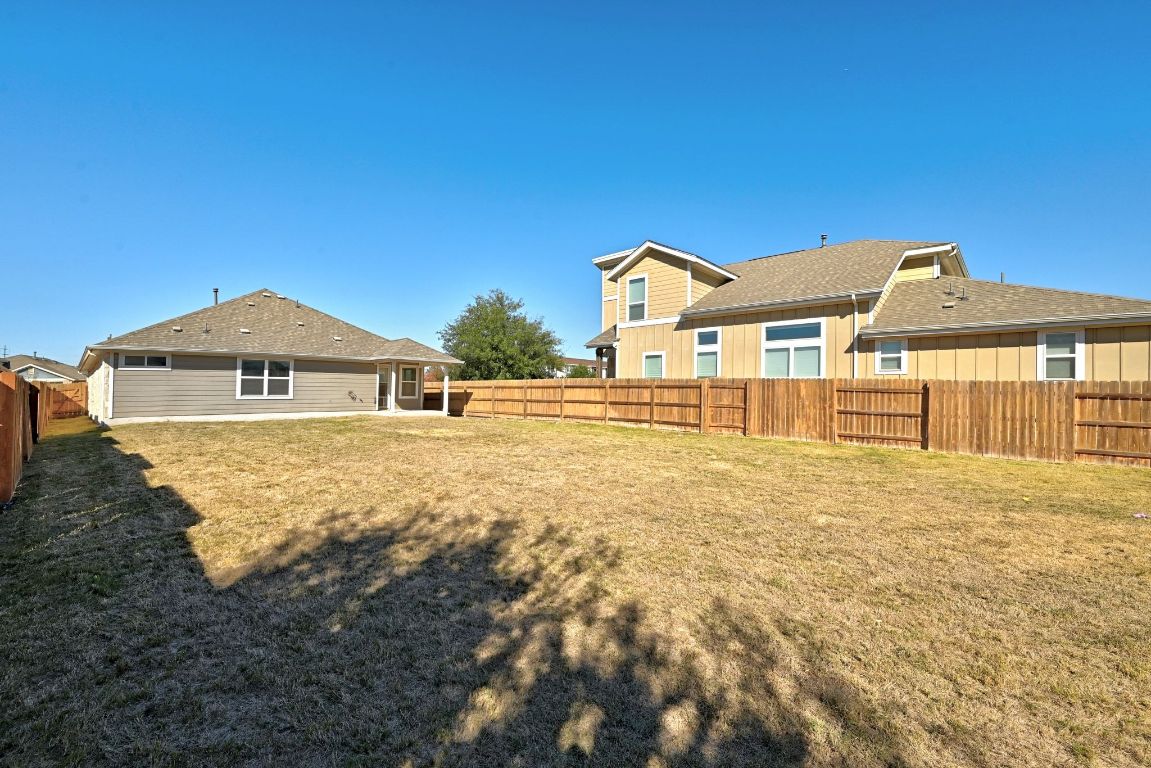 7013 Brick Slope Path Austin, TX 78744 - Photo 26 of 28 Rear view of house featuring a fenced backyard, a patio, and a shingled roof