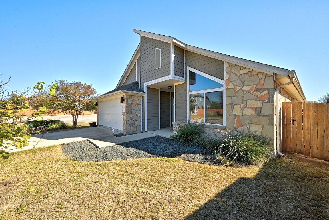 7013 Brick Slope Path Austin, TX 78744 - Photo 3 of 28 View of front of property featuring stone siding and concrete driveway