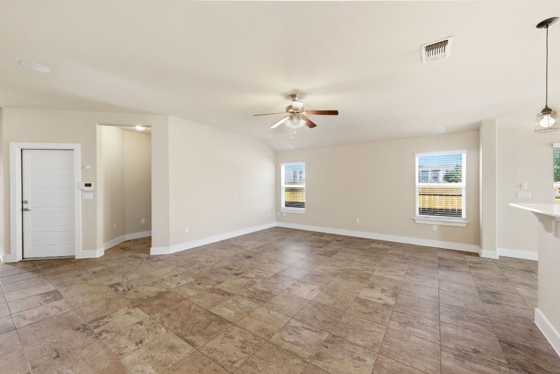 7013 Brick Slope Path Austin, TX 78744 - Photo 6 of 28 Unfurnished living room with baseboards and ceiling fan