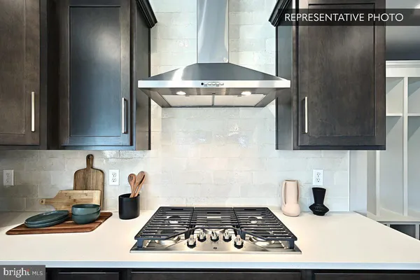 a large kitchen with lots of counter space a sink appliances and living room view