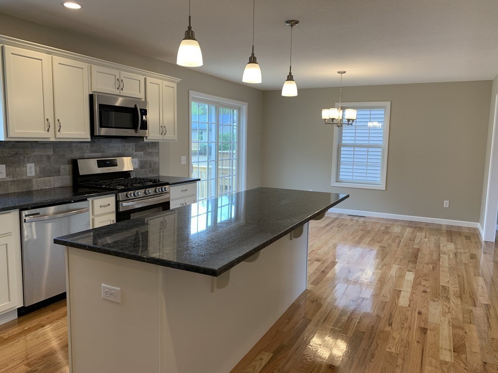 28 Howes Street Springfield, MA 01118 - Photo 3 of 16 a kitchen with stainless steel appliances granite countertop a sink a stove and microwave