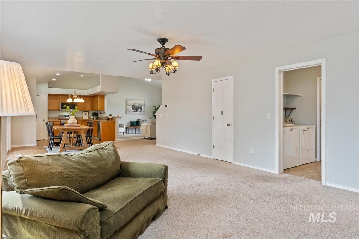 80 Cobblestone Court Middleton, ID 83644 - Photo 15 of 48 Expansive living area featuring vaulted ceilings, a ceiling fan with integrated lighting, and carpet flooring