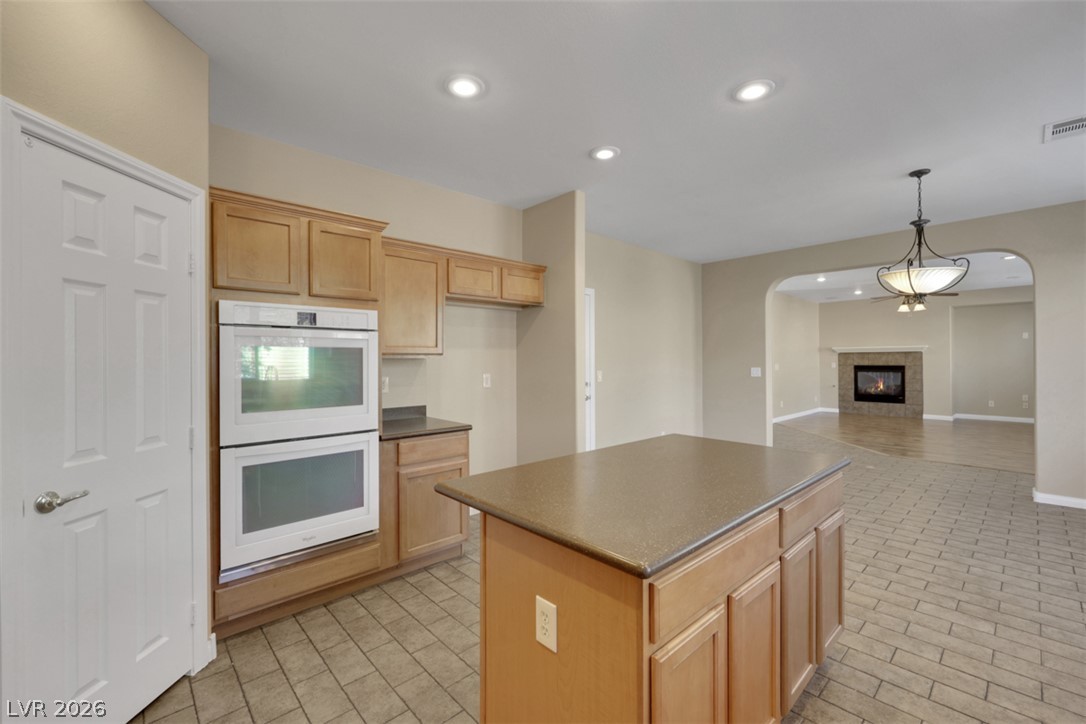 10328 Hawk Ravine Street Las Vegas, NV 89178 - Photo 15 of 55 An open kitchen design flows seamlessly into the living space, centered around a practical island with ample counter space.