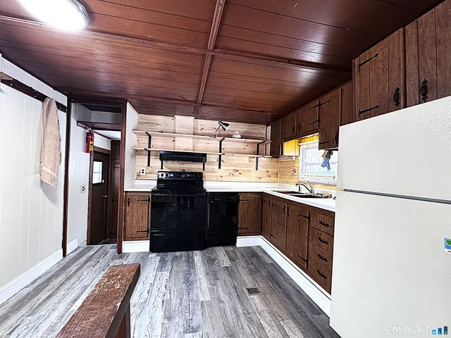 a kitchen with a refrigerator and a stove top oven