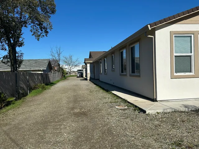 a view of a house with backyard and sitting area