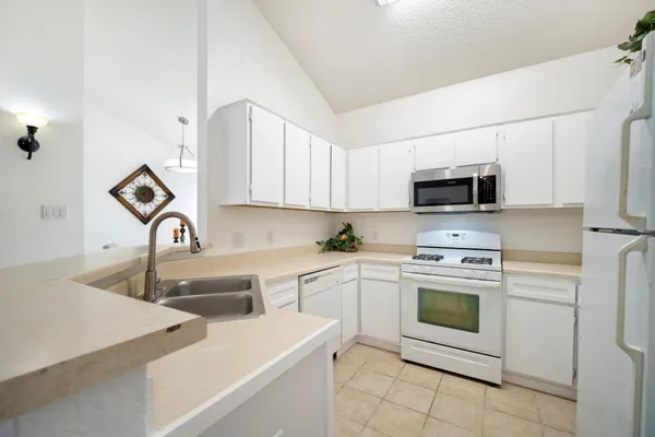 a kitchen with appliances a sink and cabinets