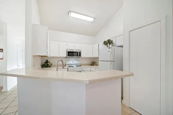 a kitchen with stainless steel appliances a refrigerator sink stove microwave and cabinets