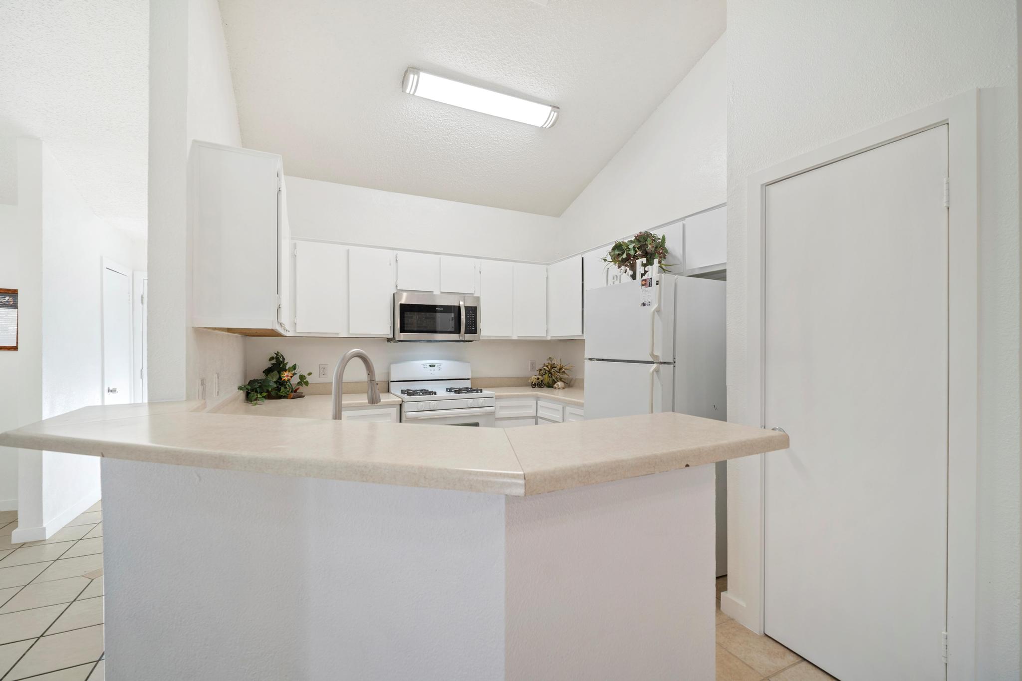 2614 Howellwood Way, Unit B Austin, TX 78748 - Photo 13 of 24 a kitchen with stainless steel appliances a refrigerator sink stove microwave and cabinets