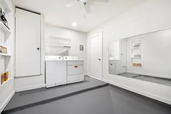 an empty room with fan and windows
