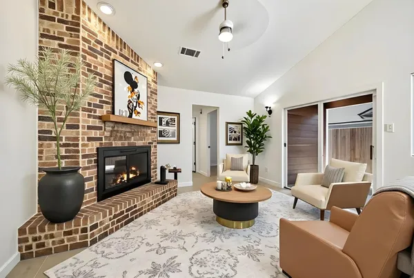 a living room with furniture a fireplace and a potted plant