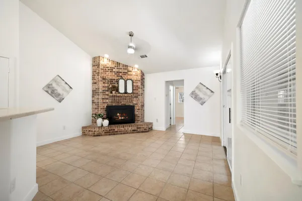 a view of an empty room with fireplace and a window