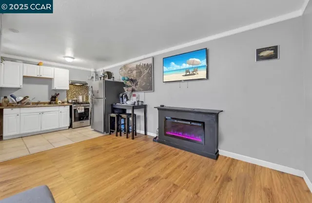 a view of a kitchen with wooden floor and a fireplace