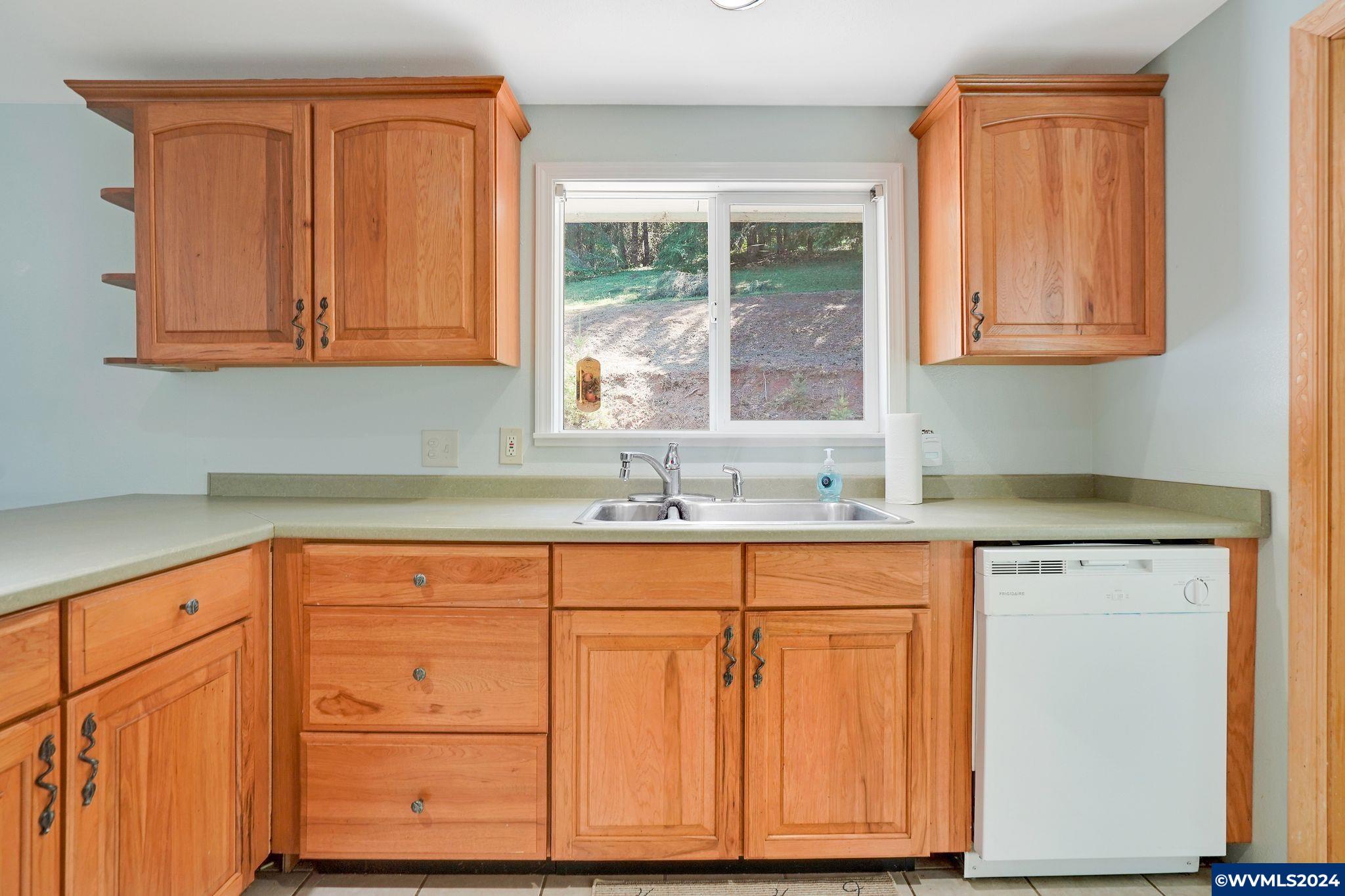 1787 Cochrane Lane Dallas, OR 97338 - Photo 23 of 42 a kitchen with granite countertop wooden cabinets a sink and a window