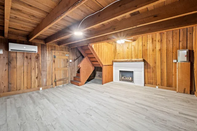 a view of empty room with wooden floor and fireplace
