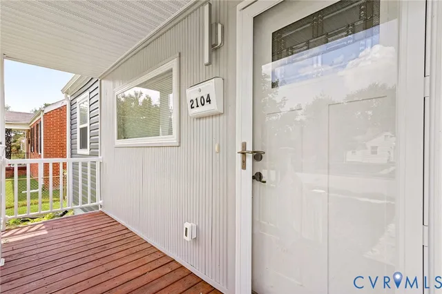 a view of a hallway with wooden floor and windows