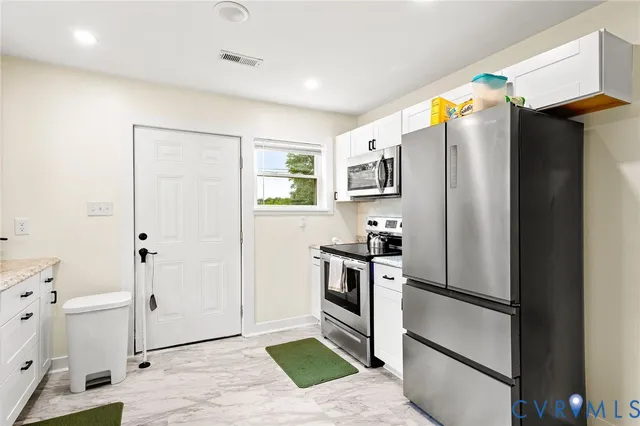 a kitchen with stainless steel appliances a refrigerator and a stove top oven