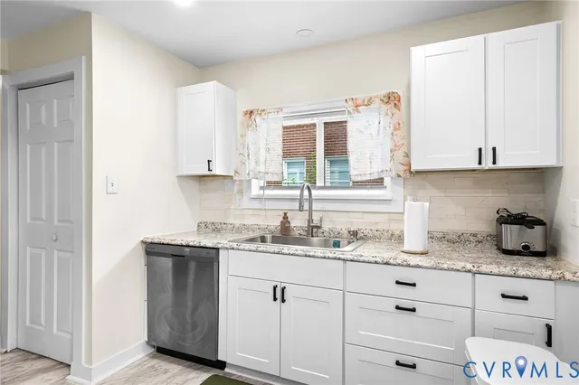 a kitchen with granite countertop white cabinets and white appliances