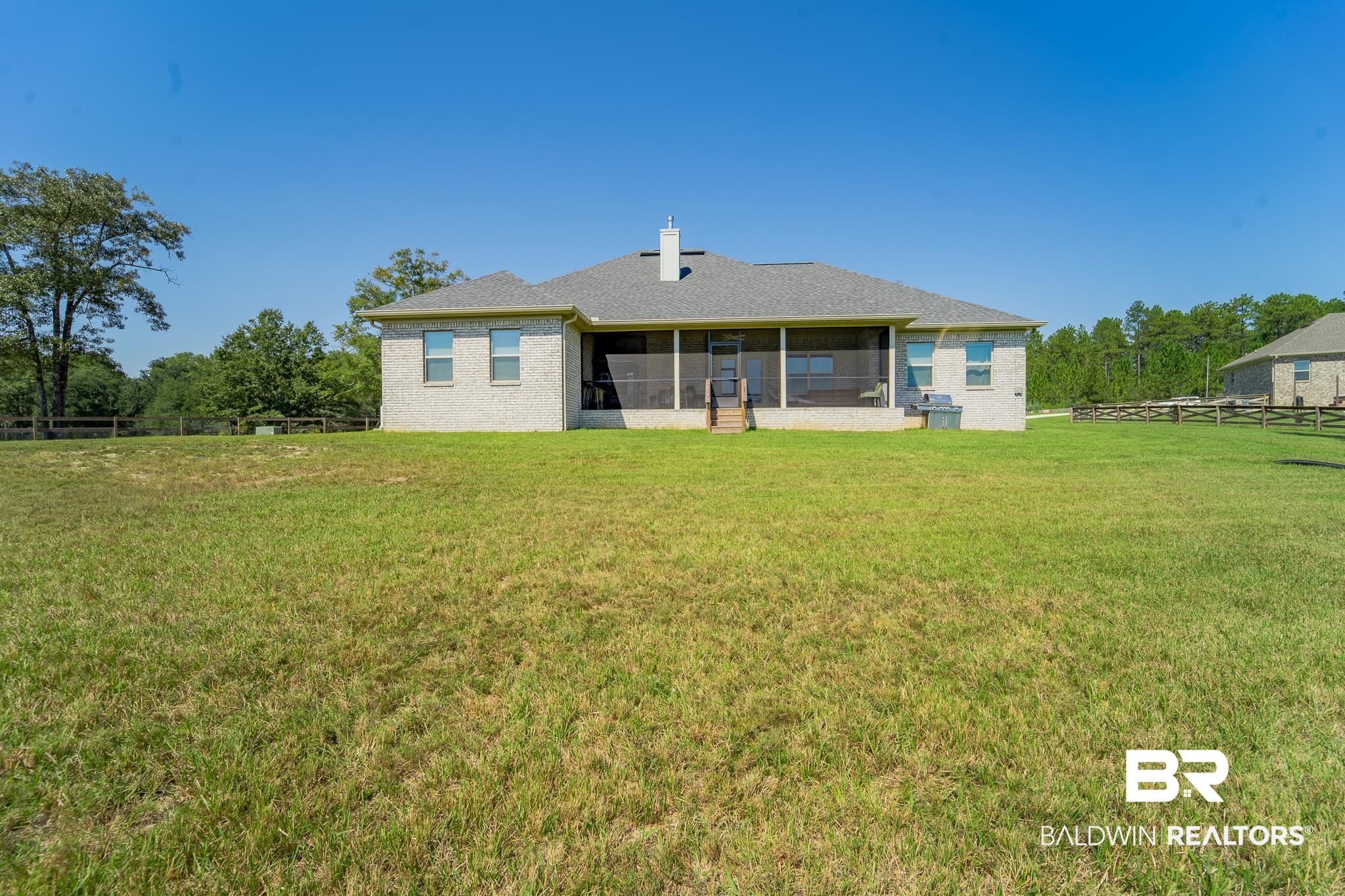 Rear view of property featuring a sunroom and a yard