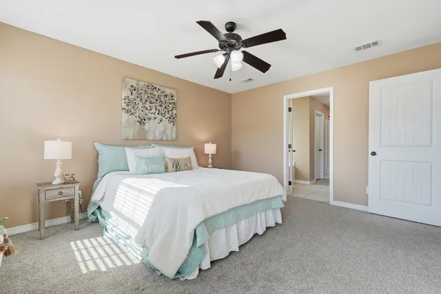 a bedroom with a bed and a ceiling fan