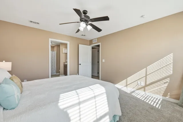 a bedroom with a large bed and a ceiling fan