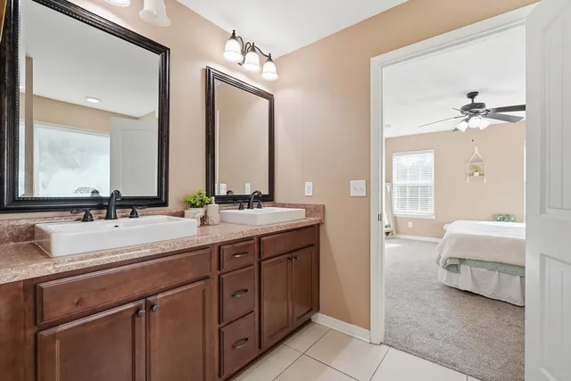a en suite bathroom with 2 sink tub and a mirror