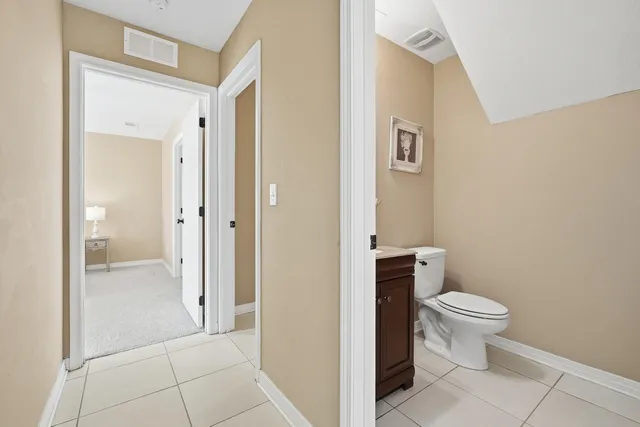 a bathroom with a granite countertop toilet a sink and a mirror