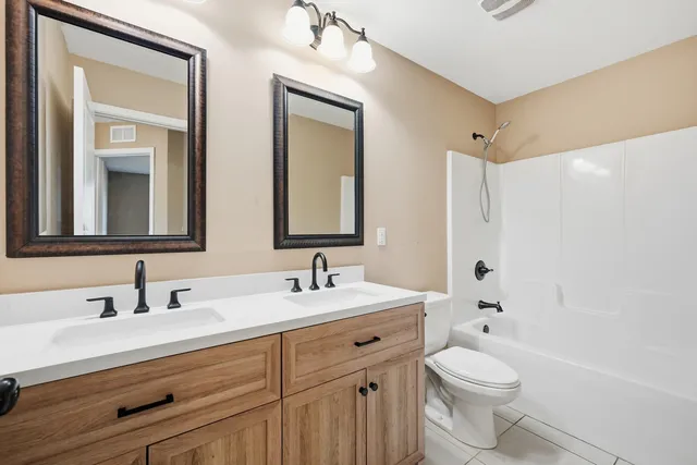a bathroom with a toilet a sink a tub and mirror