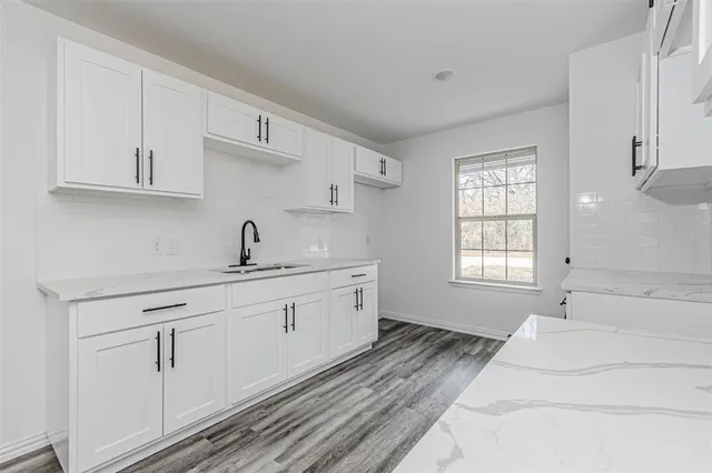 a spacious bathroom with double sink and a window