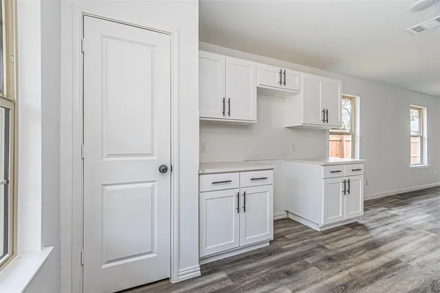 a kitchen with white cabinets and white appliances