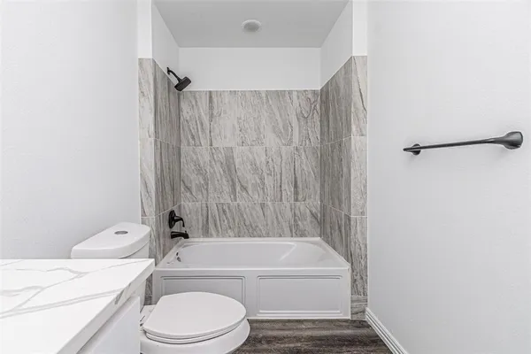 a bathroom with a toilet and a bath tub