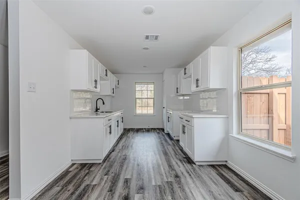 a kitchen with cabinets a window and stainless steel appliances