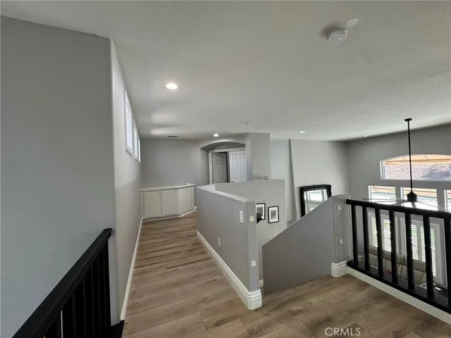a view of a hallway with wooden floor and staircase