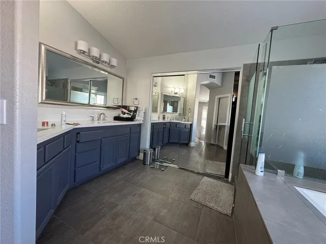 a room with a sink a mirror and a shower